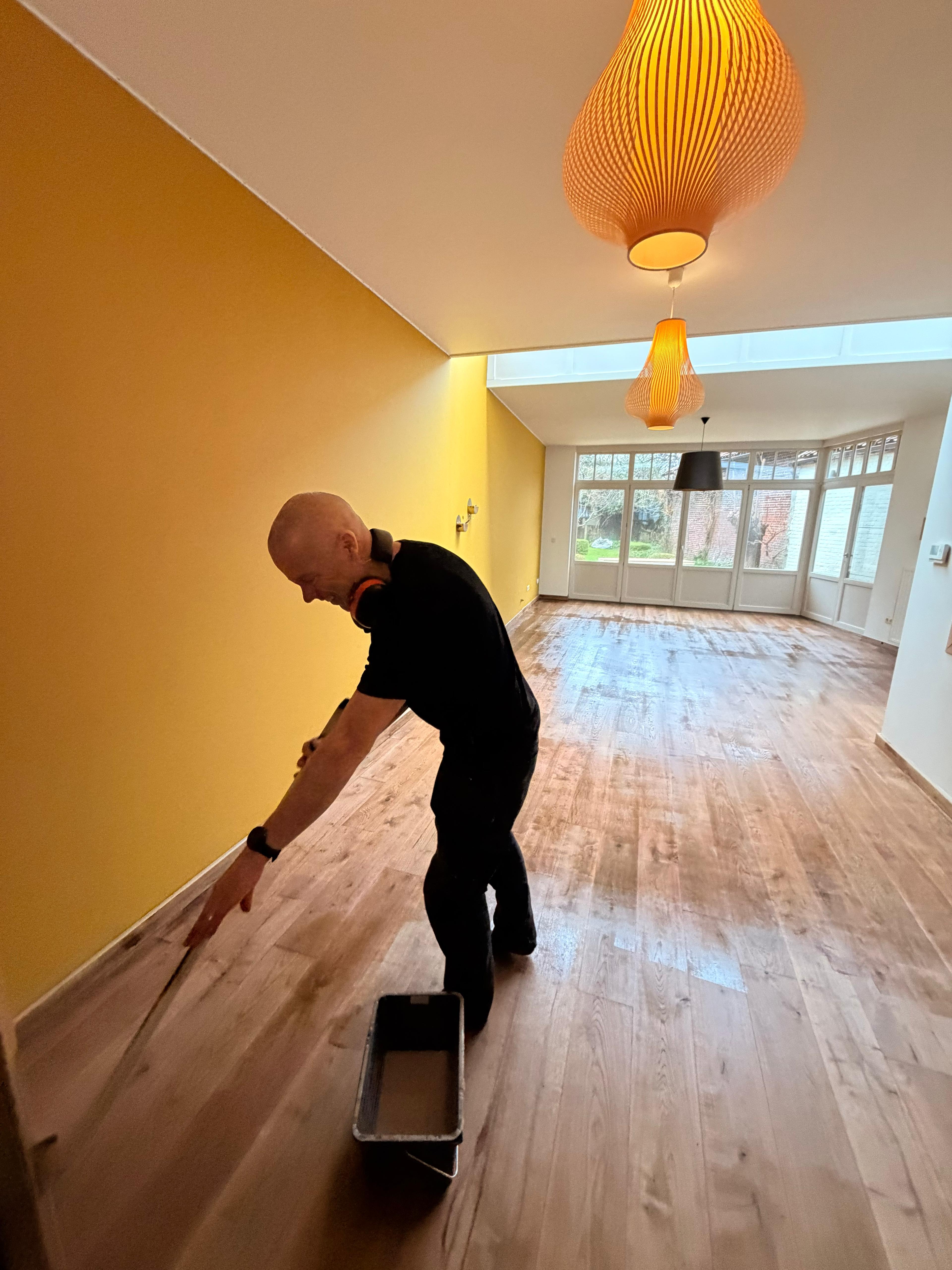 Wim Vermeersch aan het werk op een parketvloer
